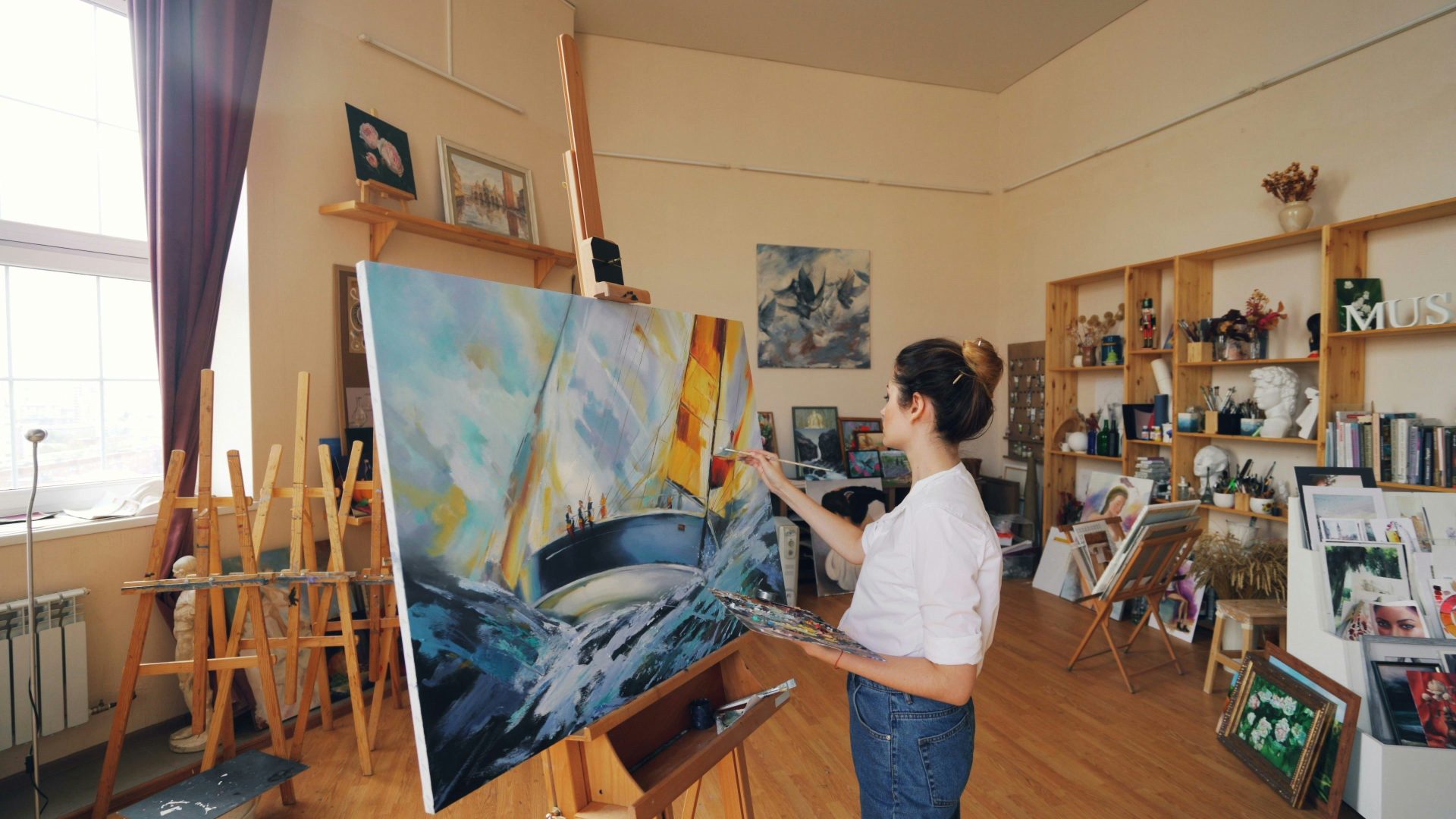 A woman paints a painting in her studio.